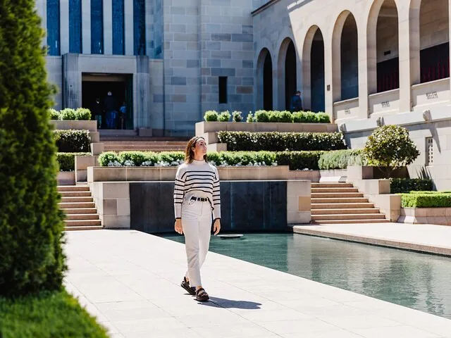 A woman walking through an outdoor courtyard at a building.